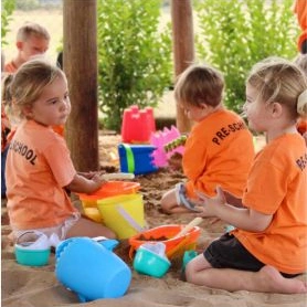Two young girls in sandpit.